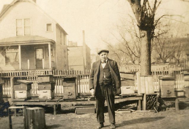 Old photo of man standing in front of house